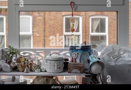 London, Großbritannien - 20. Oktober 2023 - Geräte und Sammlerstücke befinden sich in Regalen in der Nähe des Fensters. Platz für Text, selektiver Fokus. Stockfoto