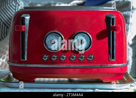 Roter Toaster im Retro-Stil zum Frühstück. Toaster im Vintage-Stil, Elektrischer Toaster aus Edelstahl, selektiver Fokus. Stockfoto