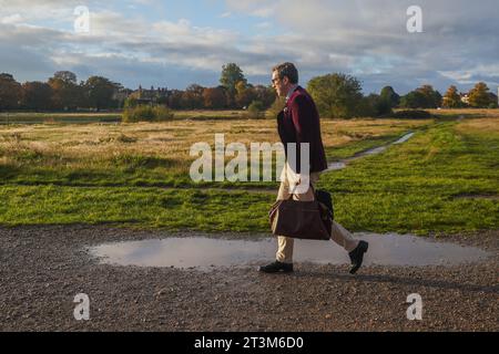 London , Vereinigtes Königreich 26. Oktober 2023. Ein Mann, der an einem hellen Herbstmorgen auf einem wasserdurchnässten Wimbledon Common von Storm Babet läuft. Credit amer Gazzal/Alamy Live News Stockfoto