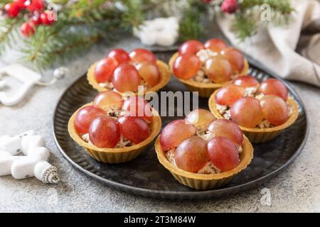 Vorspeisen zu Weihnachten. Tartlets mit Huhn und Trauben auf dem festlichen Tisch. Stockfoto