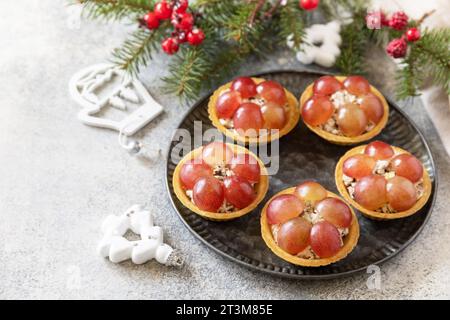 Vorspeisen zu Weihnachten. Tartlets mit Huhn und Trauben auf dem festlichen Tisch. Kopierbereich. Stockfoto