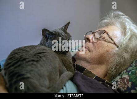 Schlafende Frau mit Katze auf der Brust Stockfoto