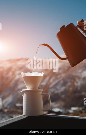 Der Barista gießt Filterkaffee mit der Hand im Freien in eine Tasse mit Wasserkocher Stockfoto