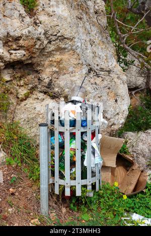 Metallmüll im Freien, der mit Müll überflutet wird, wird auf der Akropolis von Rhodos für öffentliche Zwecke aufgestellt Stockfoto