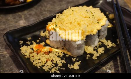 Sushi ist ein typisches japanisches Essen, das Reis mit Mayonnaise, knusprigem Mehl und einer Prise Fischeier enthält Stockfoto