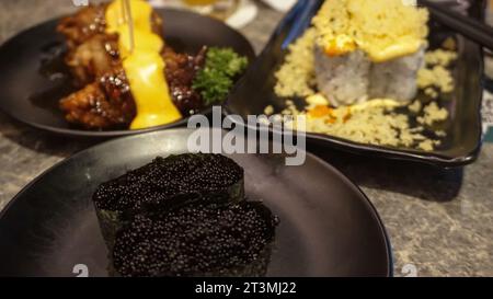 Auf der Speisekarte eines japanischen Restaurants gibt es Kaviar-Sushi, Mayonnaise-Sushi mit knusprigen Belägen und Rindfleisch-Brötchen als Ergänzung Stockfoto