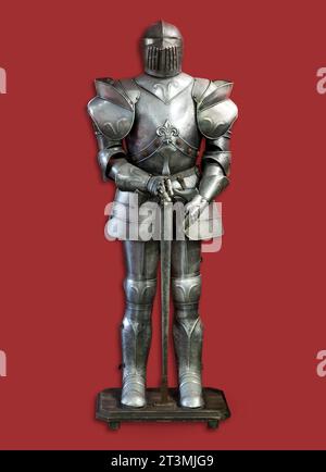 Set aus alter Metallritterrüstung auf Rack isoliert auf rotem Hintergrund Stockfoto