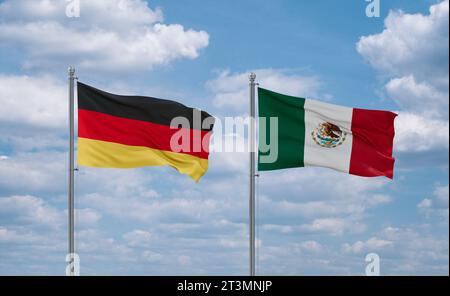 Mexikanische und deutsche Flaggen schwenken zusammen auf blauem bewölktem Himmel, zwei Länder-Beziehungskonzept Stockfoto