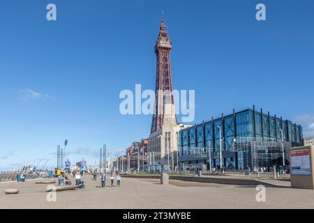 Blackpool Tower von der Promenade aus gesehen, an der Touristen entlang laufen. Stockfoto