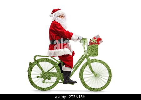 Aufnahme des Weihnachtsmanns in voller Länge, der auf einem grünen Fahrrad auf weißem Hintergrund fährt Stockfoto