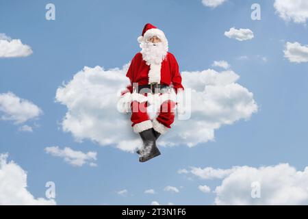 Der weihnachtsmann schwimmt auf Wolken am Himmel Stockfoto