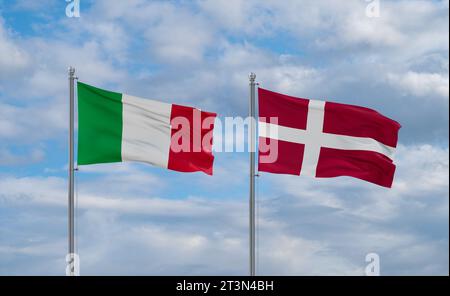 Dänische und italienische Flaggen schwenken zusammen auf blauem bewölktem Himmel, zwei Länder-Beziehungskonzept Stockfoto