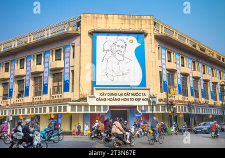 Das Wahrzeichen der riesigen Propaganda-Werbetafel, auf der Präsident Ho Chi Minh ein kleines Kind in der Ecke Trang Tien und Dinh Tien Hoang, Hanoi, Vietna hält Stockfoto