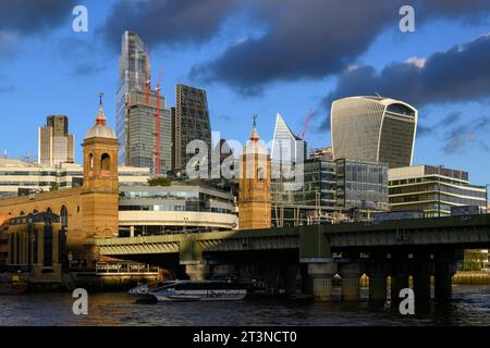 Blick auf den Fluss auf die Cannon Street Eisenbahnbrücke und den Bahnhof mit den Wolkenkratzern des Finanzviertels City of London im Hintergrund. Can Stockfoto