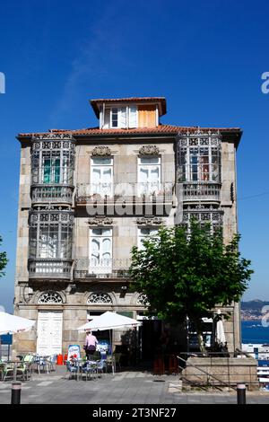 Café in typischem Granitsteingebäude mit schmiedeeisernen Balkonen und Fenstern, Vigo, Galicien, Nordwesten Spaniens Stockfoto