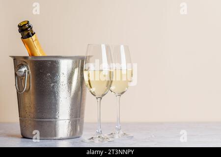 Zwei Sektgläser und eine Flasche im Eiskübel. Weihnachtsgrußkarte mit Kopierraum Stockfoto