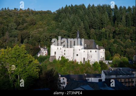 Blick auf die Gemeinde Clervaux mit Stadtstatus im Norden Luxemburgs und grünen Wald, Hauptstadt des Kantons Clervaux, weißes Schloss bei Sonnenuntergang Stockfoto