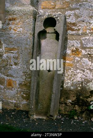 Der südliche von zwei mittelalterlichen Steinsärgen, die an der westlichen Außenwand der St Cuthbert’s Church in Elsdon, Northumberland, England, Großbritannien, anlehnen. Stockfoto