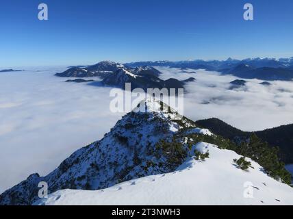 Herzogstand, Deutschland 16. November 2022: Hier am Herzogstand im Winter, Schnee, wandern, Bergsteigen, Tourismus, Ausflugsmagnet, Hotspot, Voralpen, Blick auf ein Wolkenmeer, in Richtung Jochberg, davor der Hauptgipfel mit Gipfelkreuz *** Herzogstand, Deutschland 16 November 2022 hier am Herzogstand im Winter, Schnee, Wandern, Bergsteigen, Tourismus, Ausflugsmagnet, Hotspot, Voralpen, Blick auf ein Wolkenmeer, in Richtung Jochberg, davor der Hauptgipfel mit Gipfelkreuz Credit: Imago/Alamy Live News Stockfoto