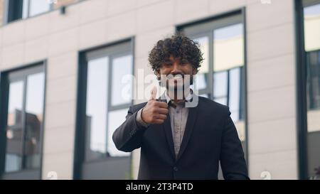 30er Jahre arabischer Unternehmer Millennials indischer Unternehmer glücklicher erfolgreicher zufriedener Geschäftsmann, der den Daumen nach oben zeigt, wie eine Geste empfehlen Stockfoto