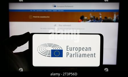 Person mit Smartphone und Logo des EU-Gesetzgebungsorgans Europäisches Parlament (EP) vor der Website. Schwerpunkt auf dem Display des Telefons. Stockfoto