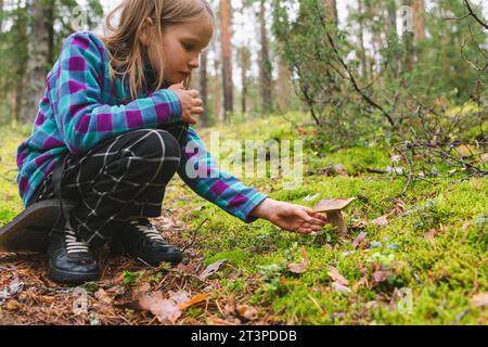 Ein Mädchen im Grundalter fand beim Camping in einem Wald den Pilz Boletus edulis (cep oder Penny Brötchen) Stockfoto