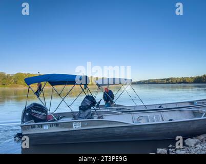 Hartsburg, MO, USA - 7. Oktober 2023: Sicherheitsboote auf einer Bootsrampe bei Sonnenaufgang vor einem Paddelrennen auf dem Missouri River. Stockfoto