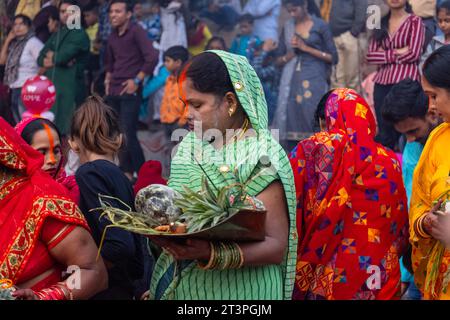 Chhath Puja, indische hinduistische Anhängerin, die Rituale von Chhath Puja durchführt, während sie im Fluss steht, um die Sonne des Herrn während des Sonnenuntergangs anzubeten. Stockfoto