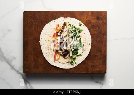 Shawarma nach libanesischer Art mit Rindfleisch und Lamm mit Zwiebeln, Gemüse und Gurken und Tomaten. Alles mit Tahini und Knoblauchsoße und Stockfoto