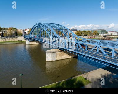 Krakau, Polen. Pilsudski blau gebundene Bogenbrücke über die Weichsel mit Autos, Bus, Straßenbahnschienen, Fußgängerbrücke und Gehweg für Fußgänger und Fahrrad l Stockfoto