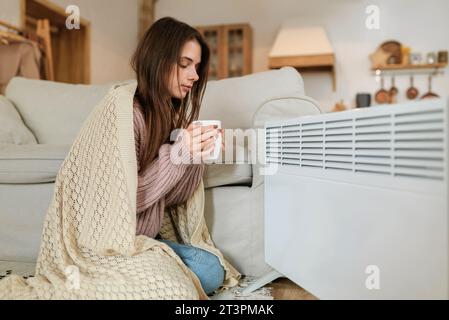 Frau, die ihre Hände wärmt. Heizsaison. Stockfoto