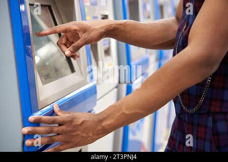 Nahaufnahme eines stilvollen afroamerikanischen Mannes, der das Terminal benutzt, um ein Ticket in der U-Bahn zu kaufen Stockfoto