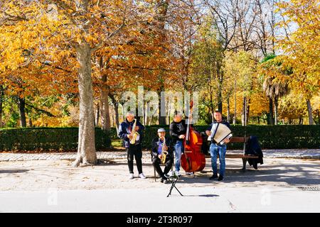 Eine Gruppe von Straßenmusikern tritt an einem Herbstmorgen auf. Parque del Buen Retiro, wörtlich „Park of the Pleasant Retreat“, Retiro Park oder einfach nur El Ret Stockfoto