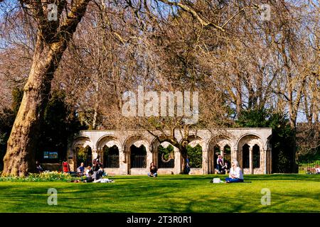 Menschen, die einen sonnigen Tag im Dean's Park im Frühjahr genießen, dem Kriegsdenkmal im Hintergrund. York, North Yorkshire, Yorkshire und The Humber, Engla Stockfoto