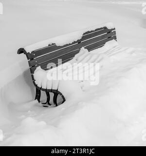 Eine Bank unter dem Schnee, im LaFontaine Park, auf dem Mont-Royal-Plateau in Montreal, Provinz Quebec, Kanada. Stockfoto