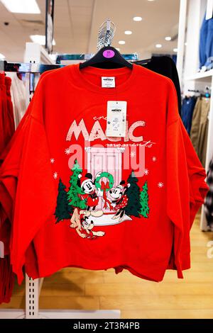 Primark 2023 Christmas Pullover Kollektion – Mini- und Micky-Maus mit Pluto-Weihnachtsszene auf rotem Pullover und „Create Magic Moment“-Schriftzug Stockfoto