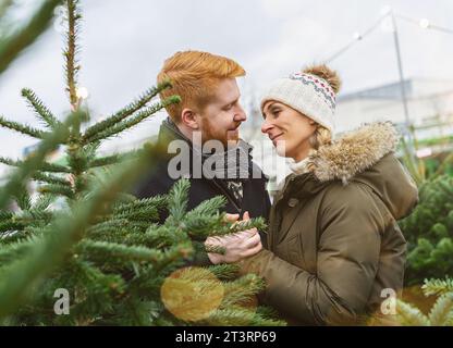 Verliebtes Paar auf einem Weihnachtsbaummarkt Stockfoto