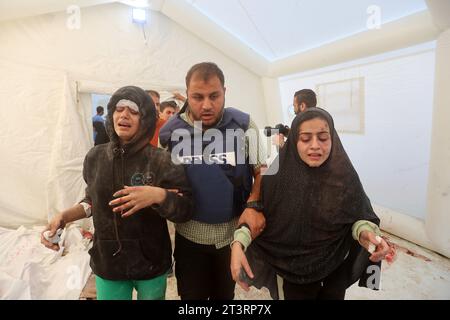 Gaza, Palästina. Oktober 2023. Hamza Al-Dahdouh der Sohn des Al-Jazeera-Korrespondenten Wael Al-Dahdouh und seine verletzten Schwestern gehen in das Al-Aqsa Krankenhaus in Deir Al-Balah, im südlichen Gazastreifen. Tausende von Zivilisten, sowohl Palästinenser als auch Israelis, sind seit dem 7. Oktober 2023 gestorben, nachdem palästinensische Hamas-Militante im Gazastreifen in den Süden Israels einmarschierten, bei einem beispiellosen Angriff, der einen Krieg auslöste, den Israel gegen die Hamas mit Vergeltungsbomben auf Gaza erklärt hatte. (Foto: Ahmed Zakot/SOPA Images/SIPA USA) Credit: SIPA USA/Alamy Live News Stockfoto