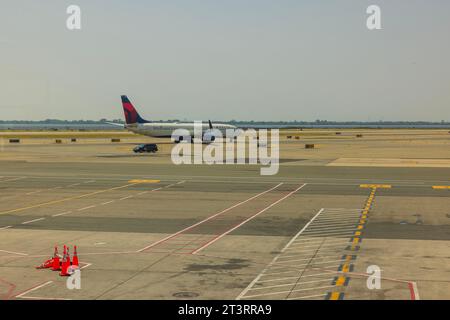 Wunderschöner Blick auf die Start- und Landebahn am klaren Morgen, mit Delta Airline, die für den Flug vorbereitet ist. USA. New York. Stockfoto