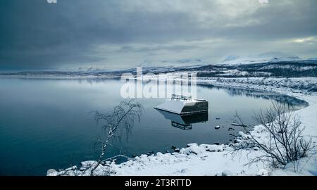 Bewölkte und friedliche Winterszene am Torneträsker See, Abisko, dem Ende der Welt Stockfoto