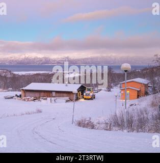 Farbenfrohes Häuschen bedeckt mit Schnee mit abisko See im Hintergrund im Abisko Nationalpark Stockfoto