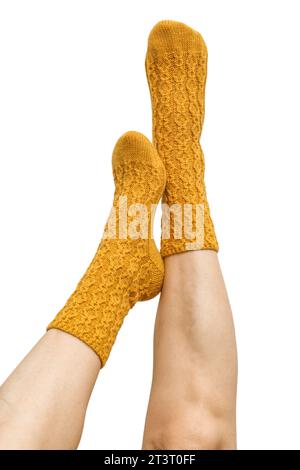 Weibliche Beine in gelben handgestrickten Wollsocken isoliert auf weißem Hintergrund, Schnittpfad inbegriffen Stockfoto