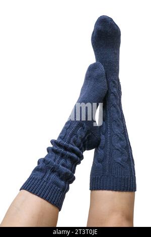 Weibliche Beine in dunkelblauen handgestrickten Kniestrümpfen aus Wolle isoliert auf weißem Hintergrund, Schneidepfad inbegriffen Stockfoto