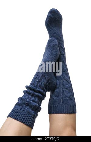 Weibliche Beine in dunkelblauen handgestrickten Kniestrümpfen aus Wolle isoliert auf weißem Hintergrund, Schneidepfad inbegriffen Stockfoto