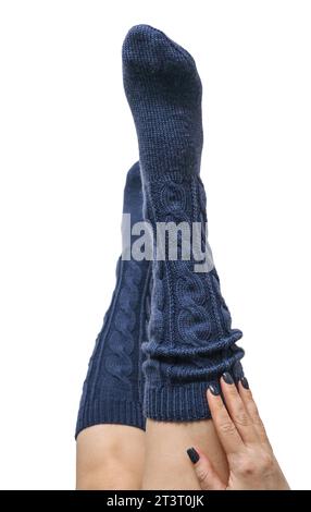 Weibliche Beine in dunkelblauen handgestrickten Kniestrümpfen aus Wolle isoliert auf weißem Hintergrund, Schneidepfad inbegriffen Stockfoto