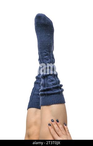 Weibliche Beine in dunkelblauen handgestrickten Kniestrümpfen aus Wolle isoliert auf weißem Hintergrund, Schneidepfad inbegriffen Stockfoto