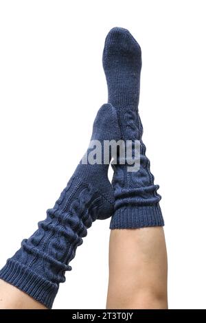 Weibliche Beine in dunkelblauen handgestrickten Kniestrümpfen aus Wolle isoliert auf weißem Hintergrund, Schneidepfad inbegriffen Stockfoto