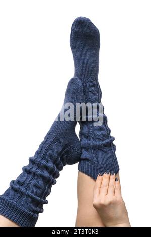 Weibliche Beine in dunkelblauen handgestrickten Kniestrümpfen aus Wolle isoliert auf weißem Hintergrund, Schneidepfad inbegriffen Stockfoto
