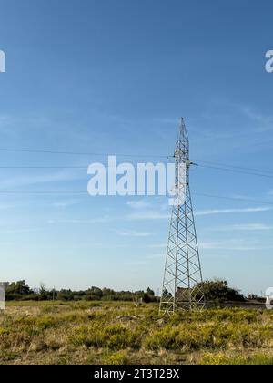 Freileitungsmast, Hochspannungspylon auf der Wiese am sonnigen Sommertag, in der Nähe von Oricum, Albanien Stockfoto