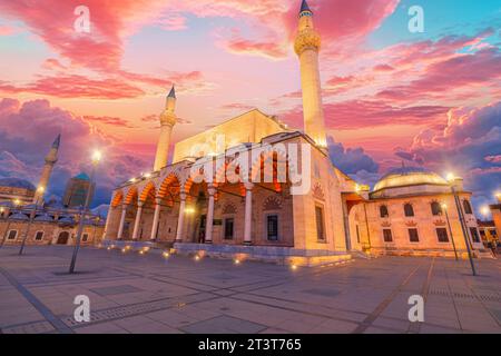 Die Selimiye-Moschee in Konya, Türkei, ist in den warmen Farbtönen des Sonnenuntergangs getaucht, mit ihren eleganten Kuppeln und Minaretten, die sich vor dem verblassenden Himmel abheben. Die Ruhe Stockfoto